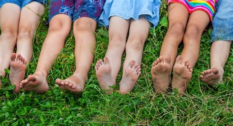 Premium Photo Childrens Feet Lie On The Grass Selective Focus Kid