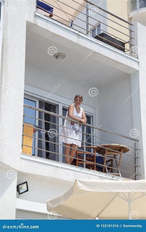 Smiling Girl Standing On The Balcony Of A Mediterranean Villa Stock