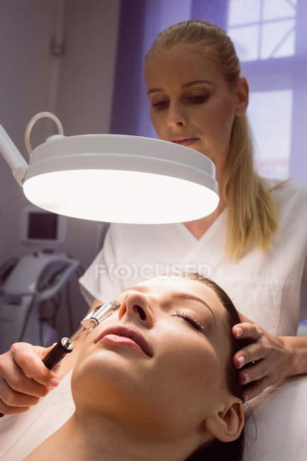 Female Dermatologist Performing Laser Hair Removal On Patient Face In