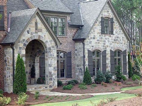 A Large Brick House With Arched Windows And Shutters On The Front