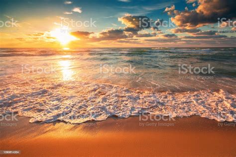 Beautiful Cloudscape Over The Sea Waves Sunrise Shot Stock Photo