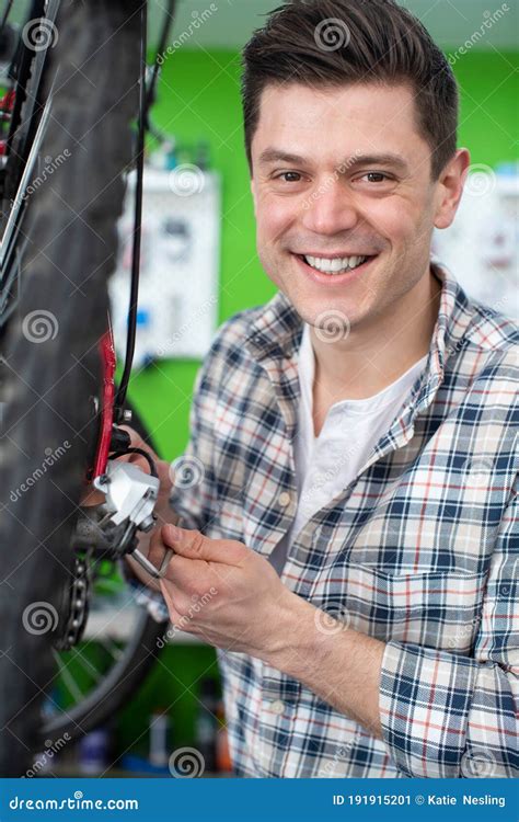 Portrait Of Male Small Business Owner Repairing Gears In Bicycle Repair