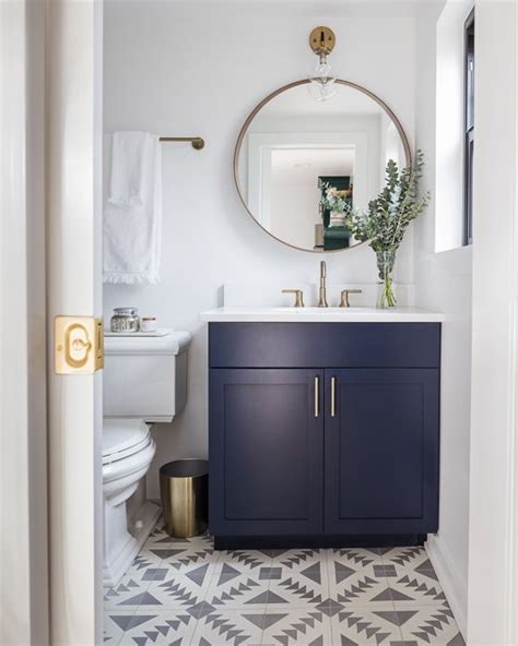 This powder room renovation was one of those someday projects that unexpectedly turned into a right this second project. modern bathroom with navy blue vanity, gold accents, and ...