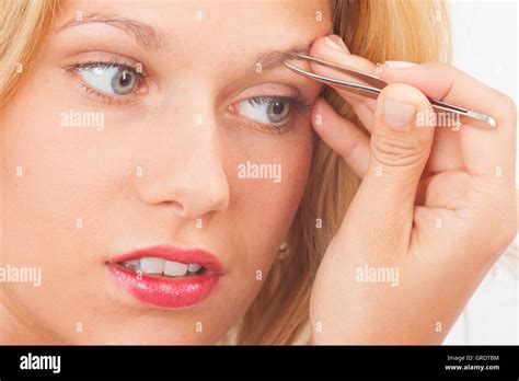 Young Woman Plucking Her Eyebrows With Tweezers Stock Photo Alamy