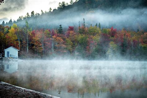 Early Morning Fog Rising Above Calm Lake In The White Mountains Of Nh