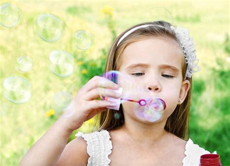 Cute Little Girl Is Blowing A Soap Bubbles Stock Photo Image Of Park