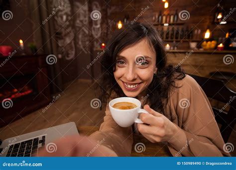 Attractive Young Woman Holding A Camera And A Cup Of Coffee Taking A