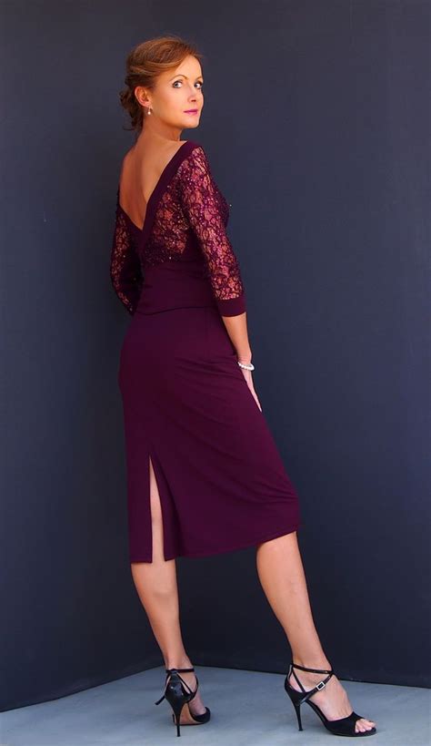A Woman In A Purple Dress Posing For The Camera With Her Hands On Her Hips