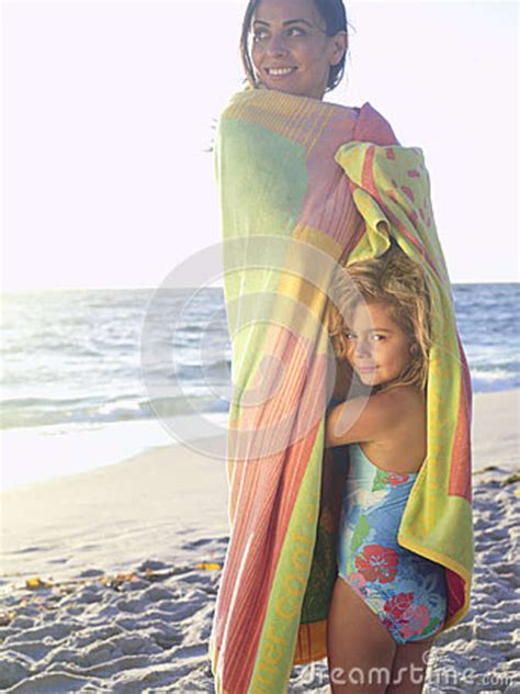 mother and daughter 5 7 wrapped in towel on beach smiling portrait of girl stock image