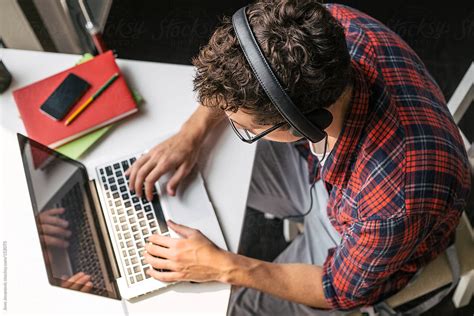 Above Angle Of Man Sitting At Desk With Computer And Headphones By