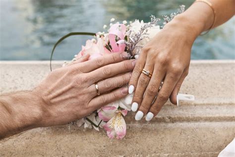 Bride And Groom Showing Wedding Rings On The Top Of Bouquet Stock Photo Image Of Flowers