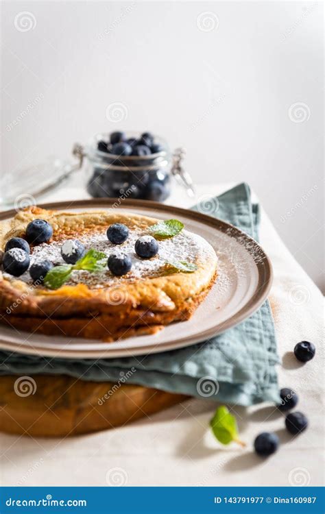 Homemade Dutch Baby Pancake With Blueberries Mint And Powdered Sugar