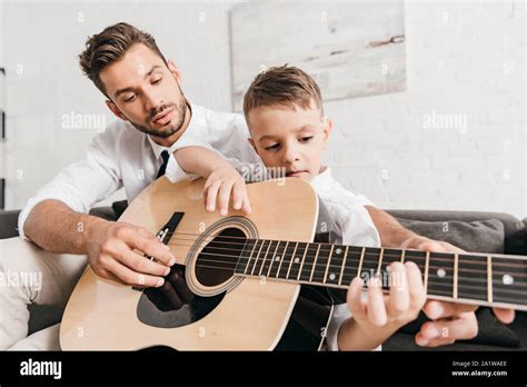 Dad Teaching Son To Play Acoustic Guitar At Home Stock Photo Alamy