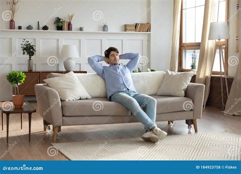 Young Caucasian Man Relax On Sofa In Design Living Room Stock Photo