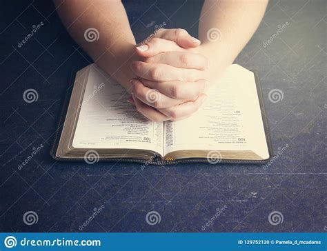 Woman Praying With Her Hands Clasped On A Bible Stock Photo Image Of