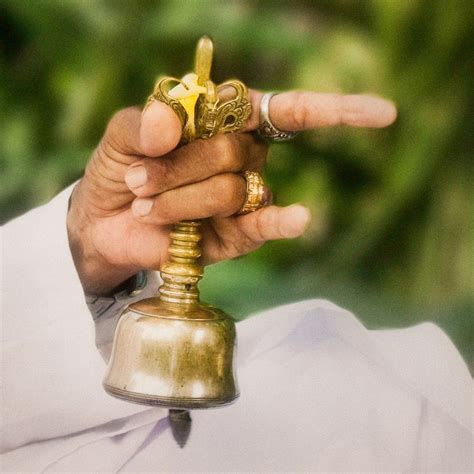 A Balinese Priests Hand Chiming A Bell During Prayer Represents