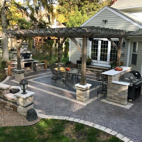 Irregular shaped flagstone pavers with beige tones hug a bank of water on the side of the patio. Top 60 Best Paver Patio Ideas - Backyard Dreamscape Designs