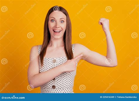 Portrait Of Excited Strong Lady Raise Hand Show Biceps Direct Finger On Yellow Background Stock