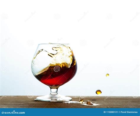 Glass Of Brandy Or Cognac Splash On The Wooden And White Background Stock Image Image Of