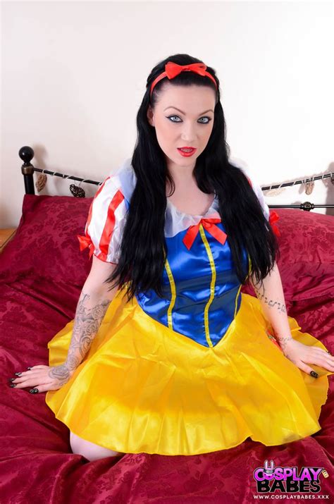 a woman dressed as snow white sitting on top of a bed