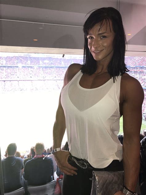 A Woman Posing For A Photo In Front Of A Crowd At A Sporting Event With
