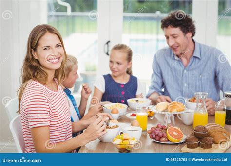 Mère Heureuse Prenant Le Petit Déjeuner Avec La Famille à La Table