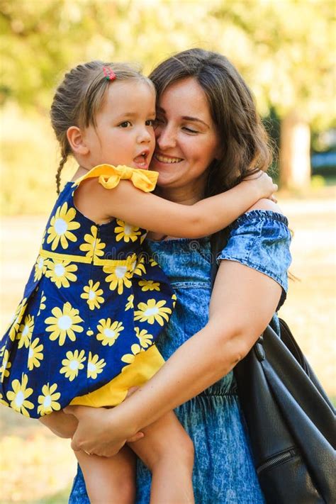 Cute Little Girl Hugging Her Mother Outdoor Shot In Park Stock Photo