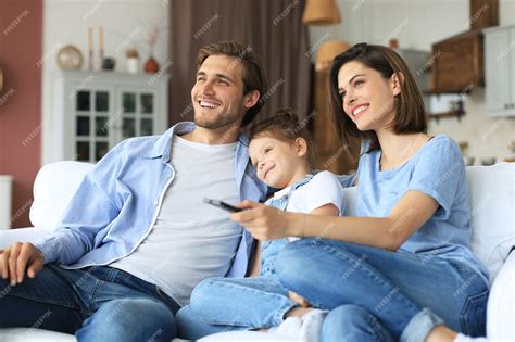 Familia Feliz Con El Niño Sentado En El Sofá Viendo La Televisión Los