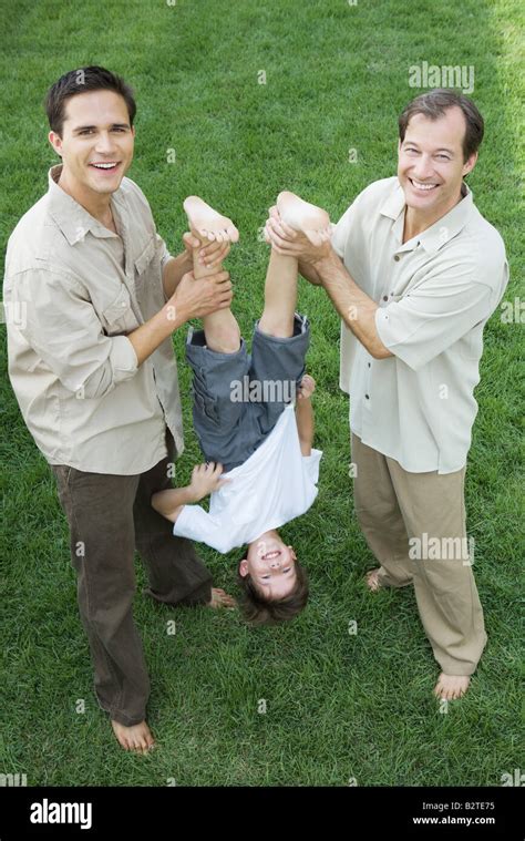 Two Men Holding Little Boy Upside Down By His Legs All Smiling High