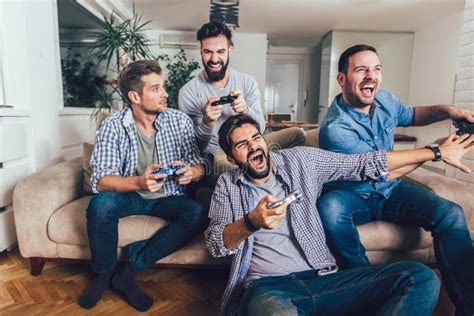 Male Friends Playing Video Games At Home And Having Fun Stock Image