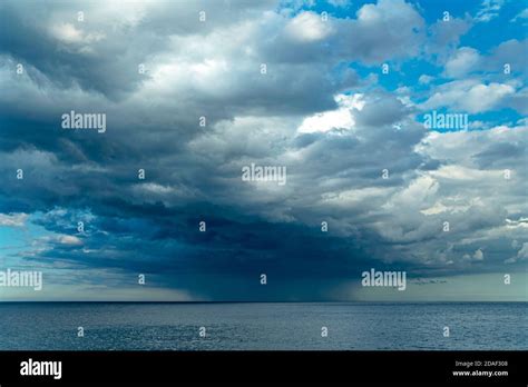 Cloudburst At Center Of Distant Cumulonimbus Rain Cloud Over Empty Calm