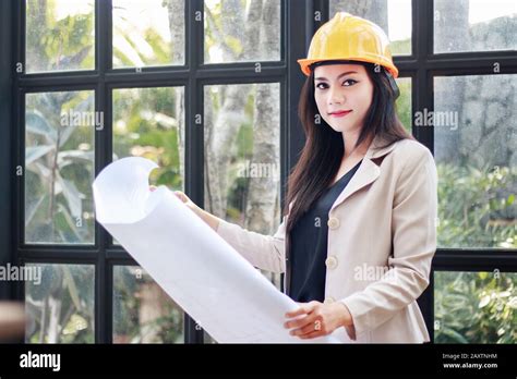 Portrait Of Beautiful Asian Woman Architect Builder With Yellow Helmet