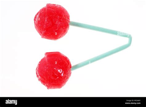 Two hard red sugar candy cherry lollipops on one folded stick, a sucker ...