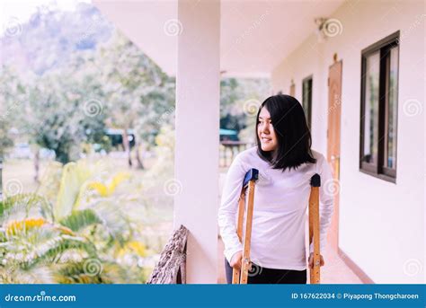 Happy Asian Woman Using Crutch And Broken Leg For Walking At Home Stock