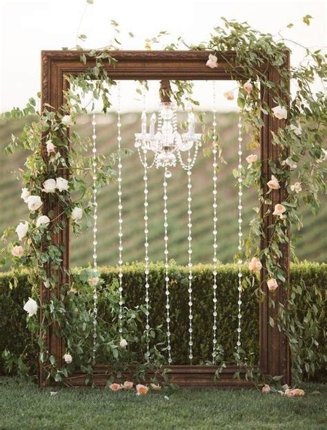A Wooden Frame With White Flowers And Pearls Hanging From It Is
