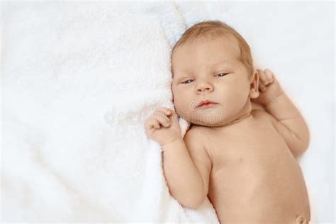 Little Newborn Baby Boy Sleeping In White Blanket Lying On Bed Stock
