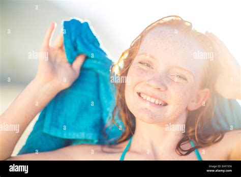 Portrait Of Smiling Girl On The Beach Drying Her Hair With A Beach