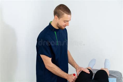 A Male Massage Therapist In A Blue Suit Makes A Sports Massage To A Woman Stock Image Image
