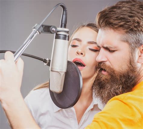 Singer Couple Is Performing A Song With A Microphone While Recording In