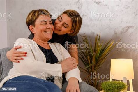 Young Woman Showering Her Mature Mother With Affection And Cuddles