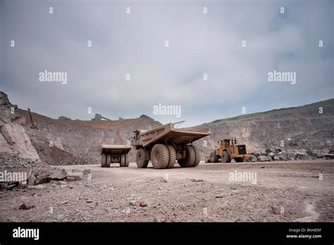 Large Haul Trucks Dump Trucks Or Earth Movers In Mine With Excavator