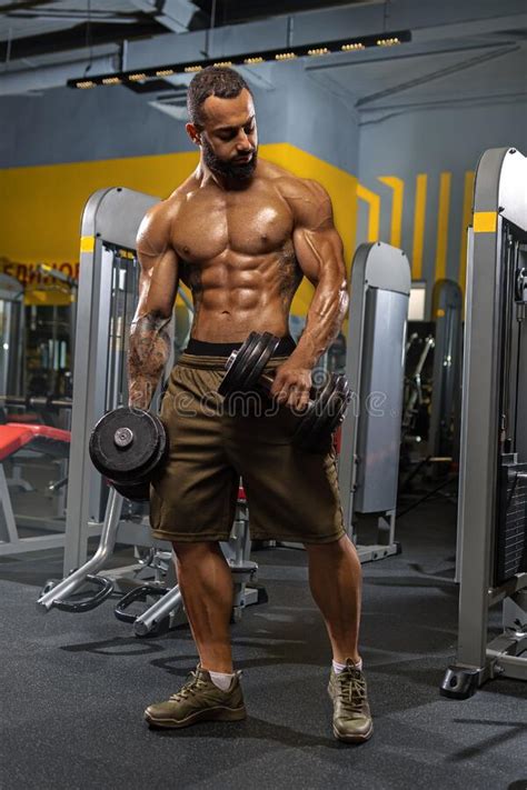 Muscular Bodybuilder Guy Doing Exercises With Dumbbell Stock Photo
