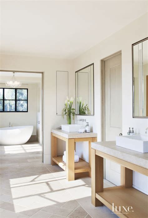 A White Bathroom With Two Sinks And A Bathtub In The Middle Of The Room