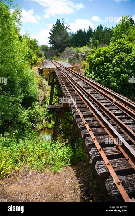 A View Along A Working Railway Track On An Old Trestle Bridge Over A