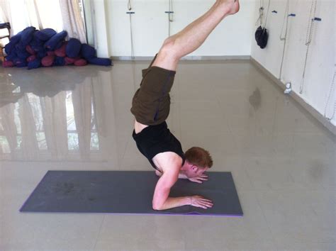 A Man Doing A Handstand On A Yoga Mat