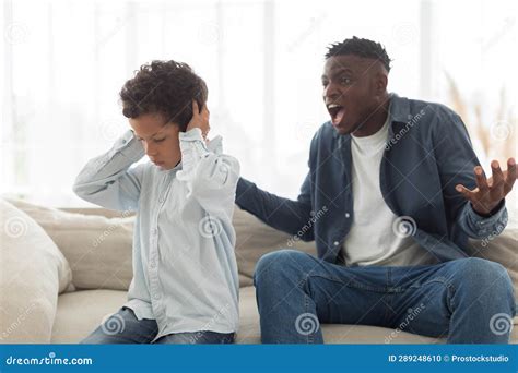 Angry Black Father Shouting At Scared Little Son At Home Stock Photo