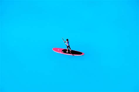 Boy Paddle Boarding On Open Blue Sea In Honolulu Oahu Hawaii