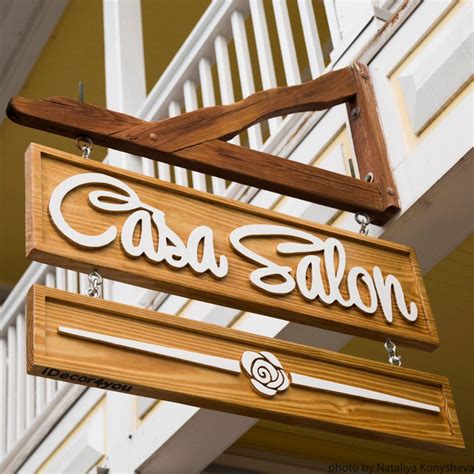 A Sign That Says Cassa Salon Hanging From The Side Of A White Building