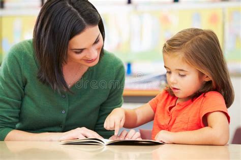 Elementary Pupil Reading With Teacher In Classroom Stock Image Image