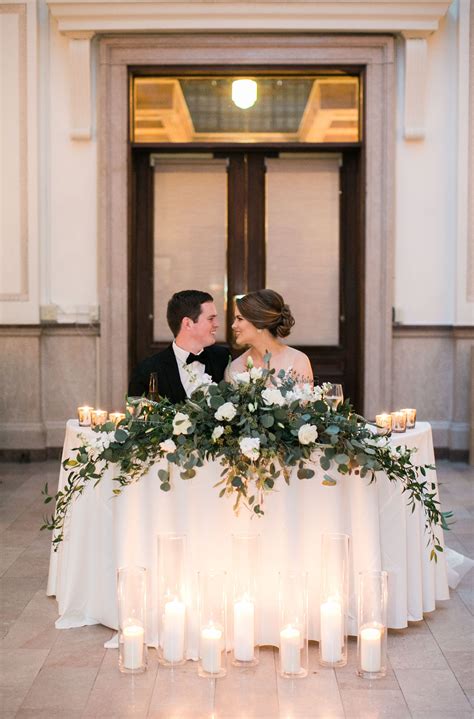 Bride And Groom And Their Romantic Sweetheart Table Greenery And White